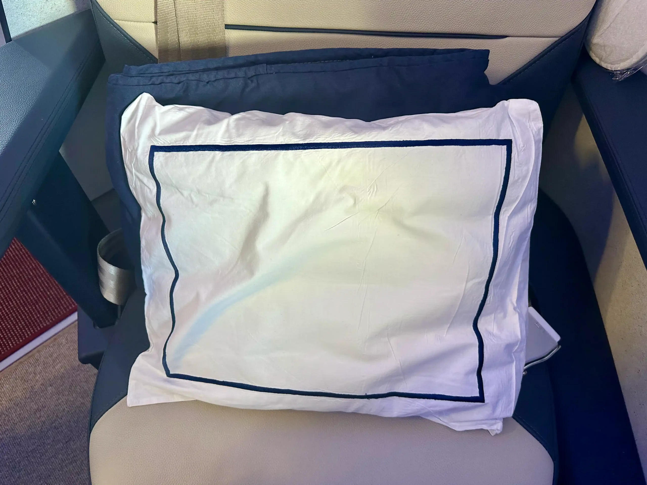 a white pillow on a blue and white pillow