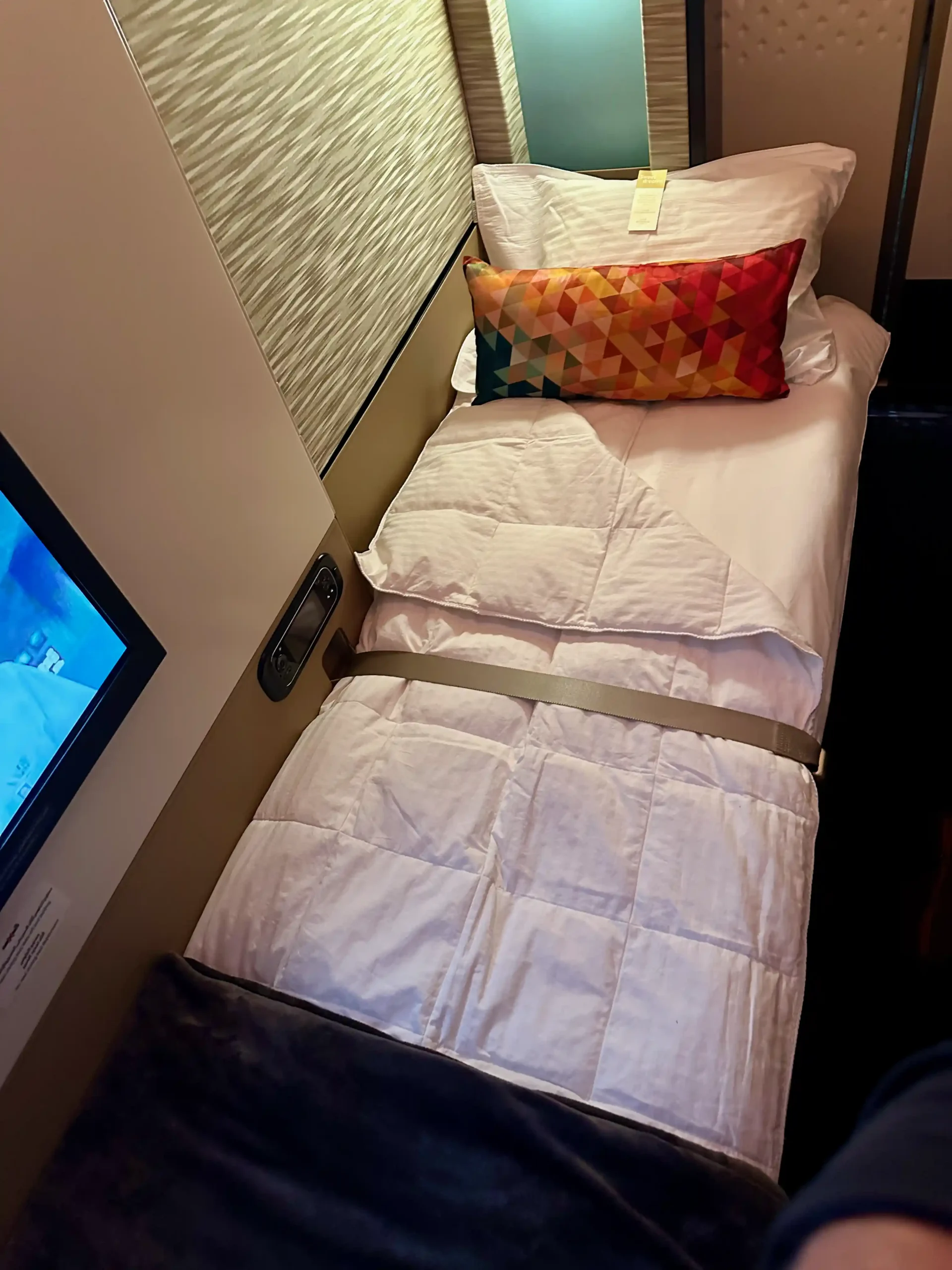 a bed with a pillow and a tv