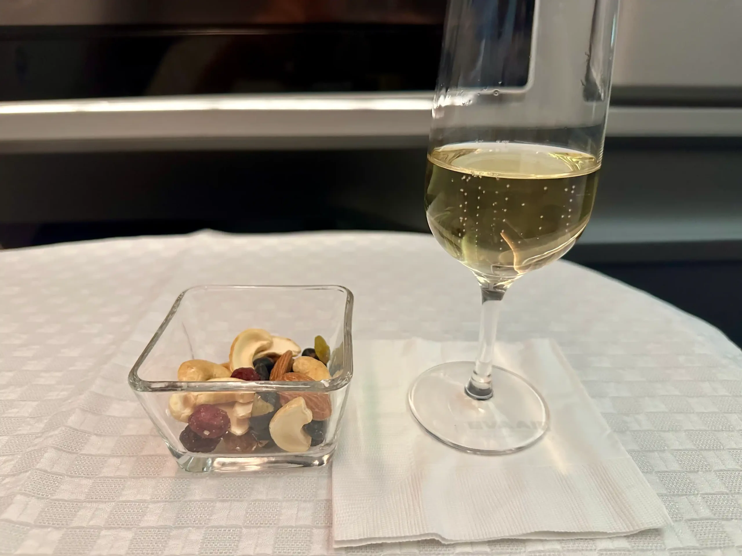 a glass of wine and a bowl of nuts